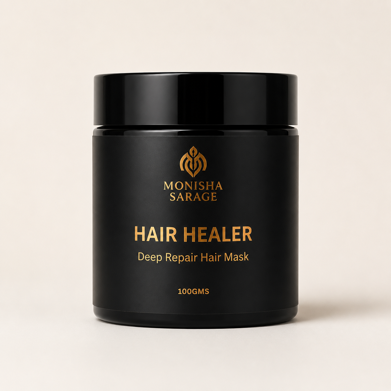 A black cylindrical jar of Monisha Sarage Hair Healer Deep Repair Hair Mask with gold lettering, set against a solid light beige background.